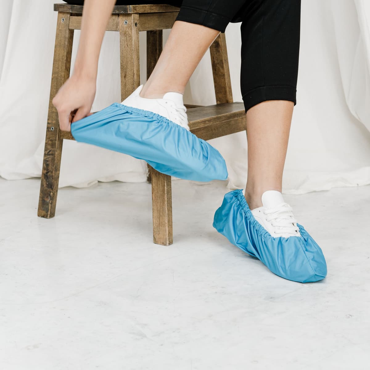 Plumber wearing shoe covers on a drop cloth inside a home