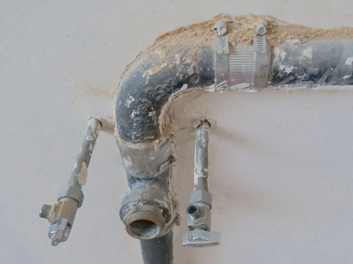 Plumber using acoustic leak detection equipment on a tile floor