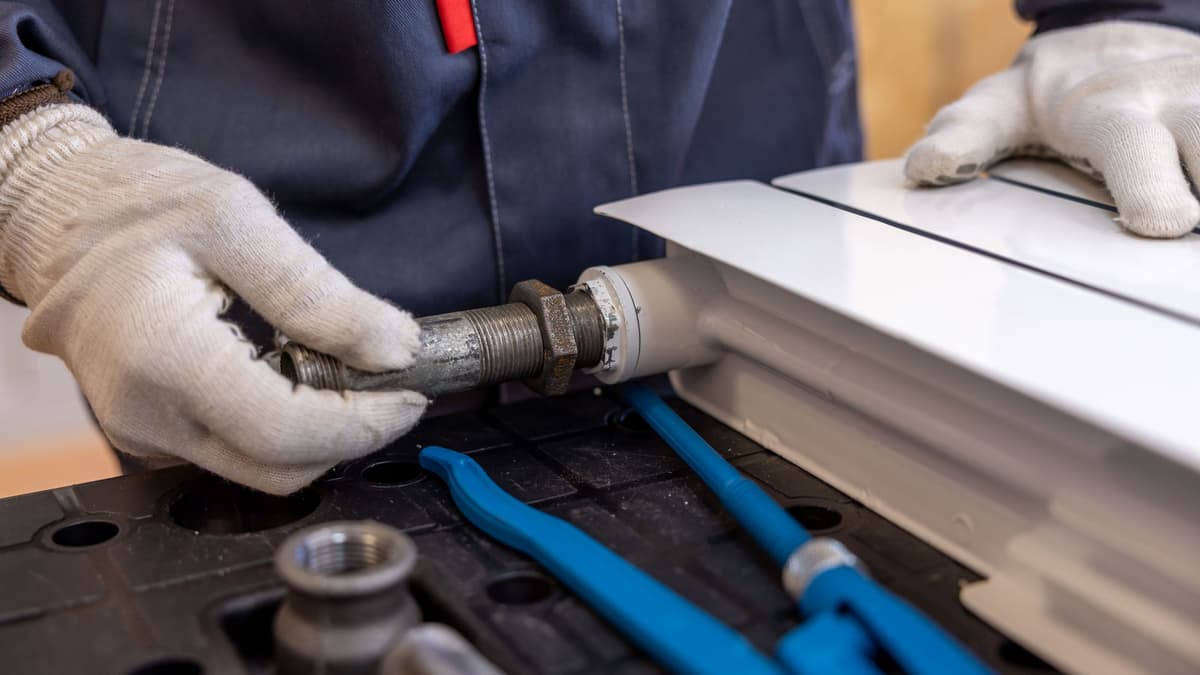 Plumber installing a water heater in a Phoenix garage